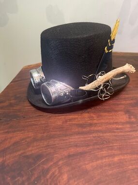Black Steampunk-Inspired Top Hat with Silver Goggles and Feather Accent